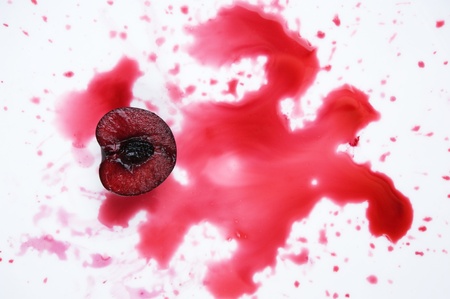 image of fresh cherry cut in halves with  cherry juice on whiteの写真素材