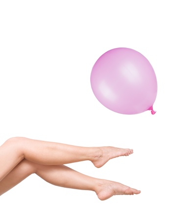 smooth and beautiful female legs with pink baloon isolated on whiteの写真素材