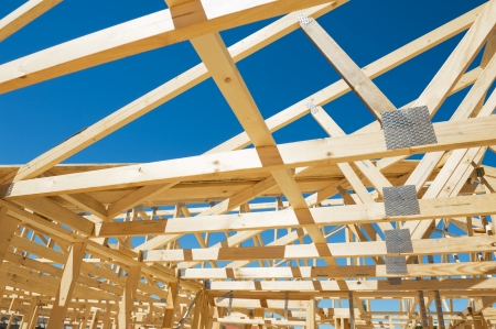 New residential construction home framing against a blue sky