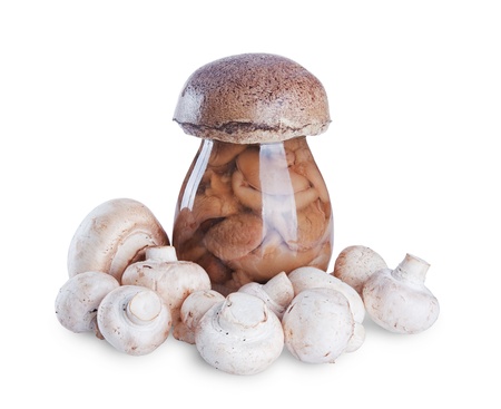 marinated mushrooms in the glass jar and fresh mushrooms isolated on white backgroundの写真素材