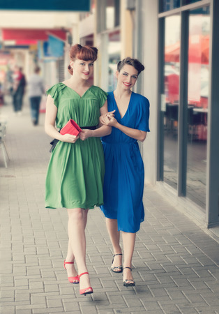 Two beautiful girls in retro style walking along the streetの写真素材
