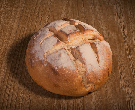 loaf of fresh homemade sour dough bread on wooden table