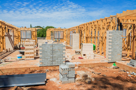 New residential construction home framing against a blue sky.のeditorial素材