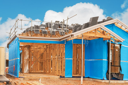 new suburban home currently under construction preparing for roofing work
against cloudy skyの写真素材