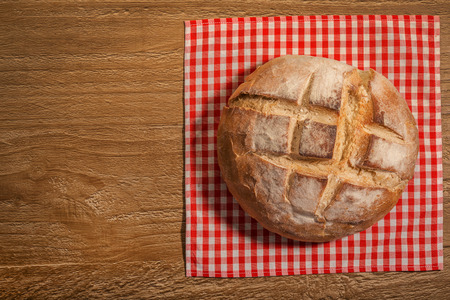 loaf of fresh homemade sour dough bread on wooden table