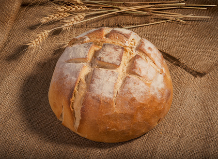 loaf of fresh homemade sour dough bread on burlap background