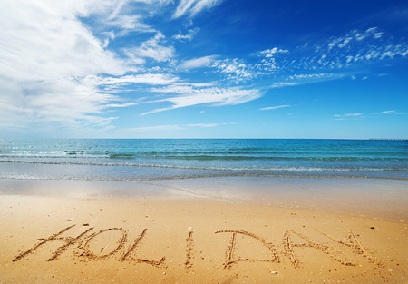 Holiday message on the beach sand - vacation and travel conceptの写真素材
