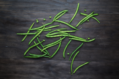 Green beans string  on an old wooden black background.Top view.