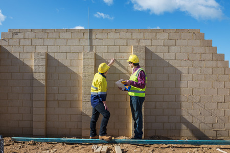 civil engineer and worker discussing issues at the construction site