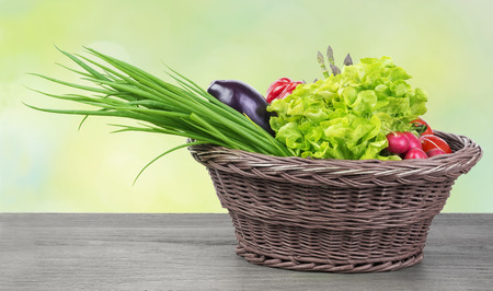 Fresh organic vegetables in a basket on wooden vintage tableの写真素材