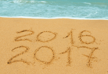 digits  2016 and 2017 on the beach - concept of new year and passing of time