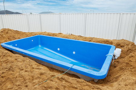  Swimming pool under construction.Installation plastic fiberglass pool in the ground at house backyard. Construction siteの写真素材