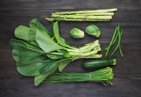 Fresh green organic vegetables on black wooden vintage table.Top viewの写真素材