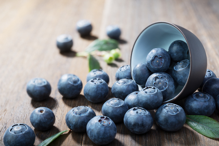 Blueberries  closeup with green leaves on rustic  wooden table.Concept healthy eatingの写真素材
