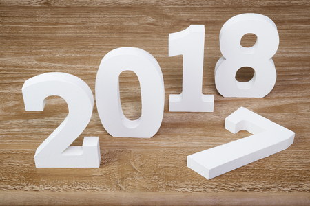 White digits 2018 and digit 7 on rustic  wooden background as concept of New Year and Christmas.