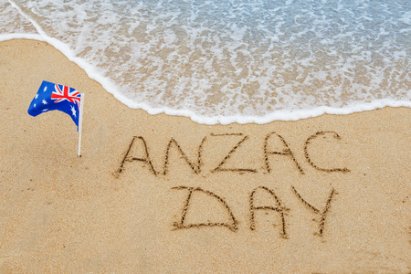 Words Anzac day and Australian flag on the sand of seashore.Lest we forget の写真素材