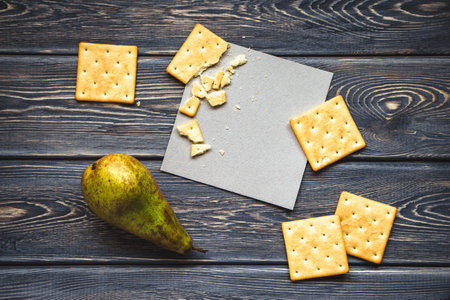 A healthy breakfast with biscuits and pear on old wooden table. Mockup of greeting card. Flat lay. Top view.の写真素材