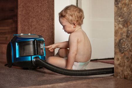 the child is studying the vacuum cleanerのeditorial素材