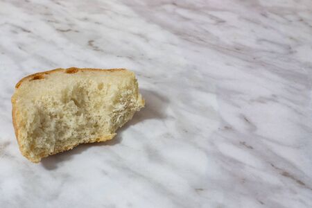 bitten piece of old white bread on the table