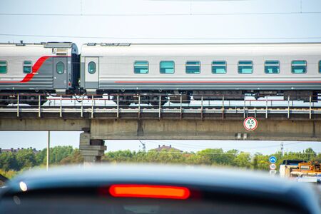 fast train goes over the highway on which cars go, in the summer