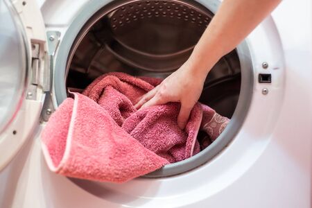 open door of the washing machine with dirty laundryの写真素材