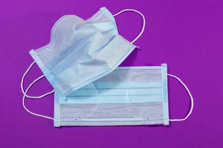 medical mask on a purple background, personal protective equipment against airborne diseasesの写真素材
