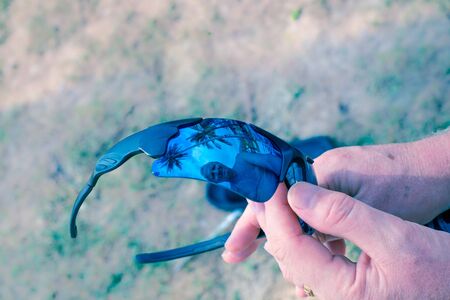 a man looks at the reflection in sunglasses, vacation at sea, blue tintedの写真素材
