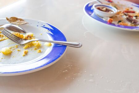 empty plates with cutlery after dinner in a cafe, dirty dishes, copy space