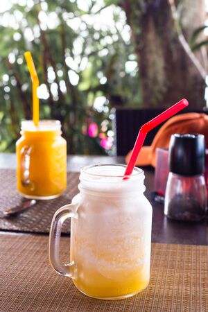 mango fruit smoothies stand on a table in a cafe, soft drinks on vacationの写真素材