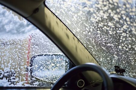 car wash, soap foam on glass, view from the passenger compartment
