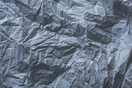 background from crumpled texture paper of dark gray color, a template for the text