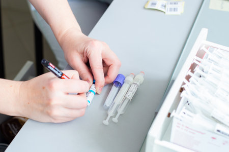 Khmao-Yugra, Russia-09.06.2020: a nurse signs empty plastic tubes for blood sampling for analysis, diagnosis of coronavirus, diseases, infections, concept medicineのeditorial素材