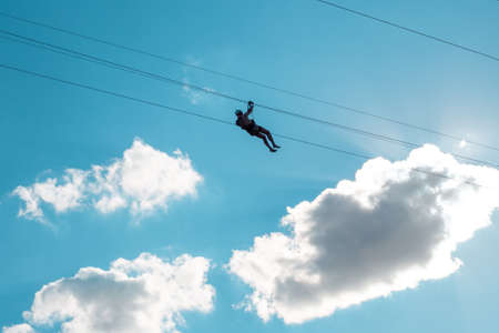 man on zipline ride high in the sky. Extreme entertainment.の写真素材