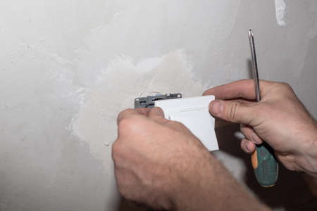 dismantling the socket from the wall. Repair and installation of electrical wiring.