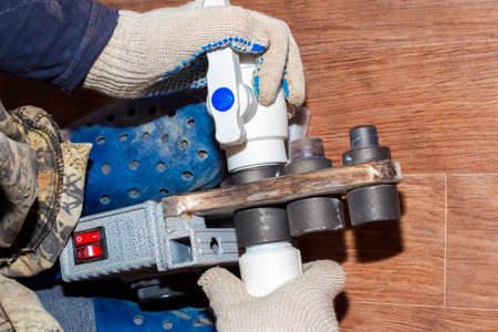 a plumber solders parts of a polypropylene water pipe using heating, assembly and installation of...