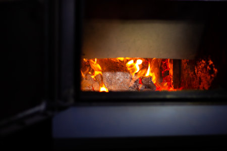 Fuel stove with burning coals. Heating the house in winter