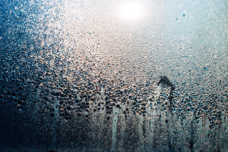 Misted window with drops of moisture that glows in the sun.Texture, template for text.の写真素材