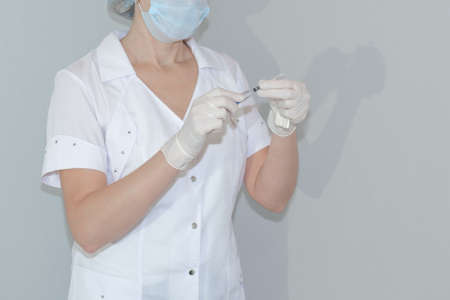 A nurse holds a syringe with a vaccine in her hands. Worldwide immunization of the population.