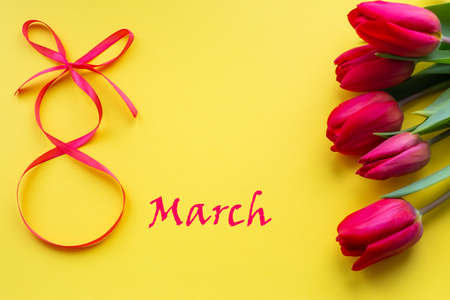 bouquet of tulips and the inscription March 8 on a yellow background. Congratulations on the...