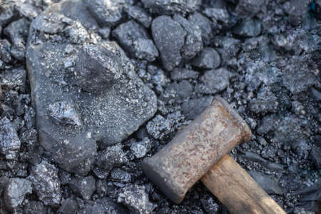 Large sledgehammer for breaking large pieces of coal, mineral fuel for home stoves and boilers. Heating country houses.の写真素材