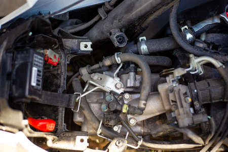 Repair and dismantling of a motorcycle. After removing the motorcycle seat, the engine is visible.