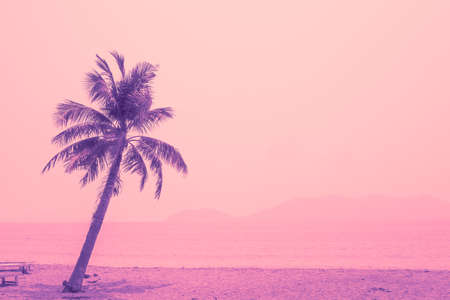 Tropical coconut tree against the background of the sea, bright purple and pink tint. Travel and...