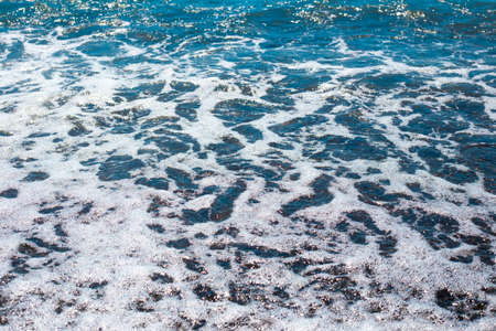 Coastal wave with foam. Sea water surface. Texture, wallpaper, template for text.の写真素材