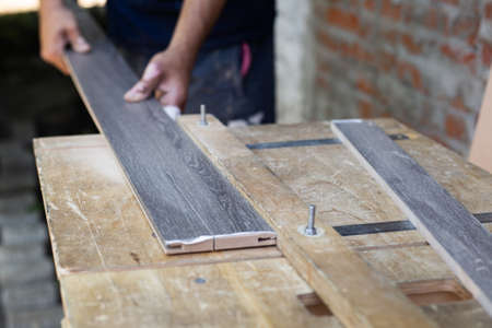 Manufacturing and installation of doors. A carpenter cuts a wooden plank on a lathe.の写真素材