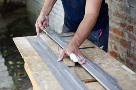 The wooden plank is sawn lengthwise on the machine. Carpentry work.