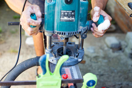 A carpenter works with a wood milling machine. Professional tools for woodworking.