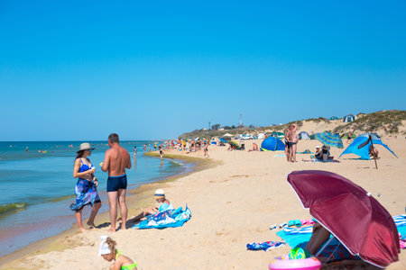 Anapa, Russia-09.08.2020: Tourists swim and sunbathe on the sandy beach of the Black Sea coast. Travel and tourism. Summer vacation and weekendのeditorial素材