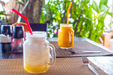 Cold smoothie made from mango and pineapple fruits on the table in a cafe. Rest in tropical countries, gastronomic tourism.の写真素材