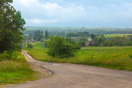 Rural landscape. Country road in a village with houses and vegetable gardens on a summer day.の写真素材