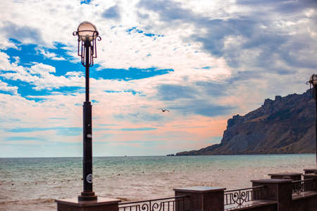 Evening sea landscape. Embankment overlooking the mountain and the sea, dark cloudy sky. Travel and tourism.の写真素材
